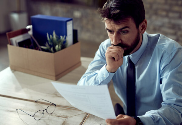Young distraught businessman reading a notice after being fired is debt relief legal in India